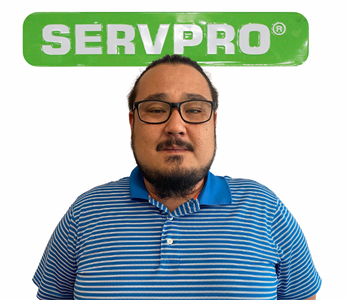Jay posing for SERVPRO photo on white wall 